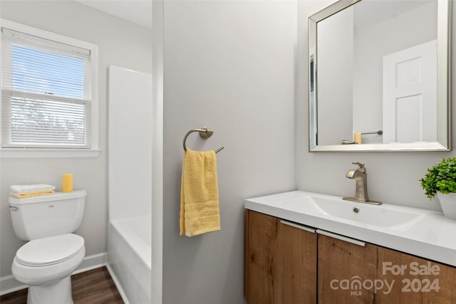 bathroom featuring toilet, vanity, and hardwood / wood-style flooring