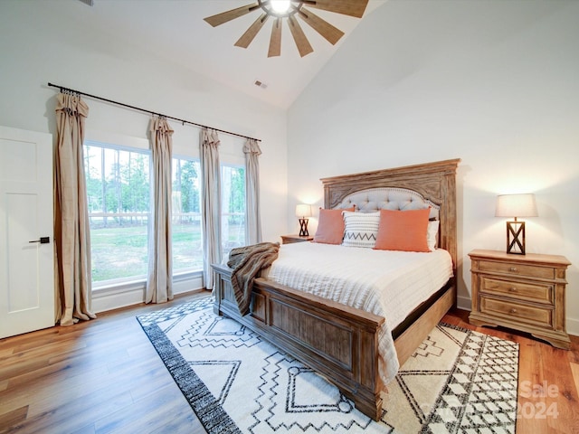 bedroom with light wood-type flooring, high vaulted ceiling, and ceiling fan