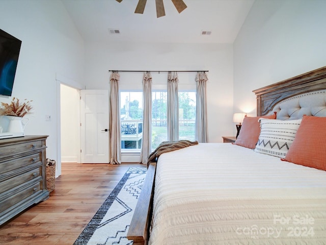 bedroom featuring ceiling fan, light hardwood / wood-style floors, and high vaulted ceiling