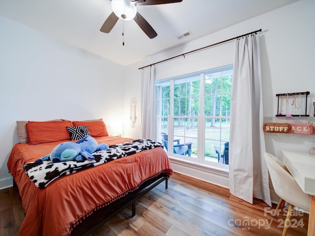 bedroom featuring wood-type flooring, multiple windows, and ceiling fan