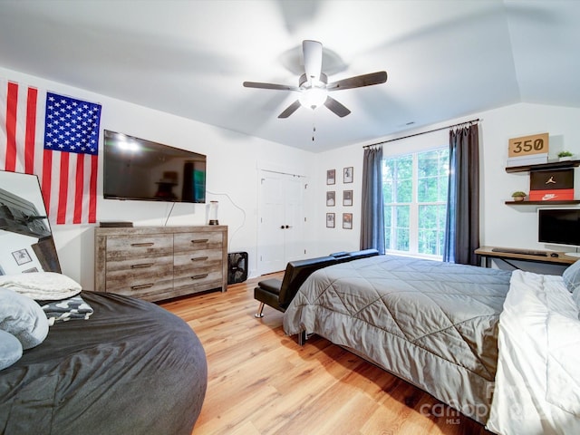 bedroom featuring a closet, light hardwood / wood-style floors, ceiling fan, and lofted ceiling