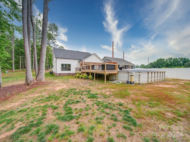 rear view of house featuring a yard and a deck