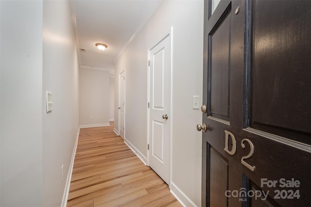 hallway featuring light hardwood / wood-style floors and crown molding