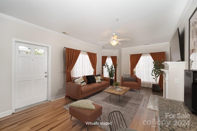 living room featuring light hardwood / wood-style flooring, a wealth of natural light, ornamental molding, and ceiling fan