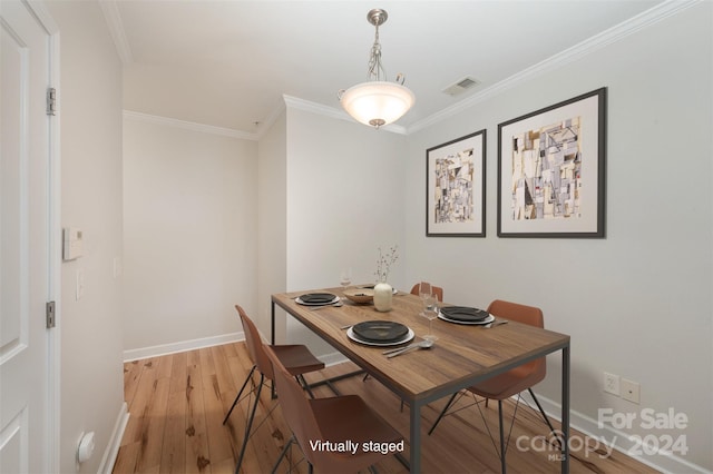 dining room featuring light wood-type flooring and ornamental molding