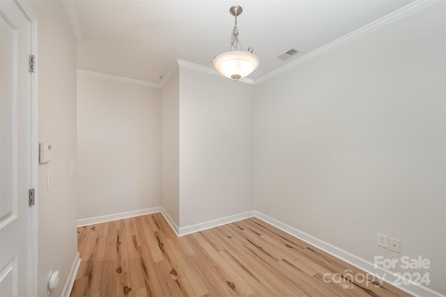 empty room with light wood-type flooring and crown molding