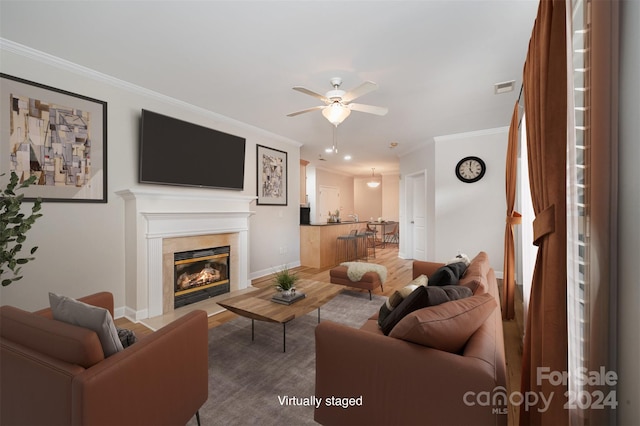 living room with hardwood / wood-style floors, ceiling fan, and crown molding