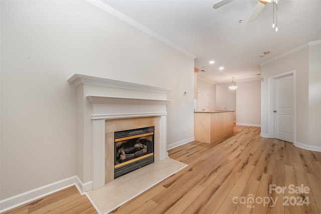 unfurnished living room with a high end fireplace, light hardwood / wood-style floors, ceiling fan, and crown molding