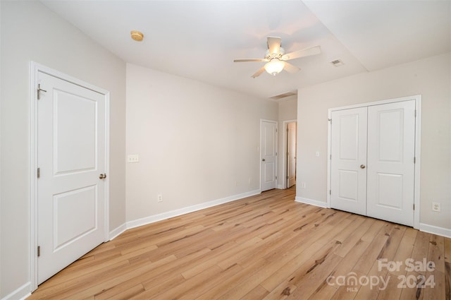 unfurnished bedroom featuring a closet, light hardwood / wood-style floors, and ceiling fan