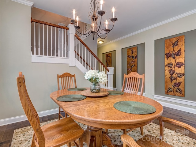 dining room with dark wood-type flooring, ornamental molding, and a chandelier