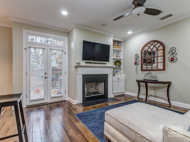 living room with ornamental molding, dark wood-type flooring, ceiling fan, and french doors