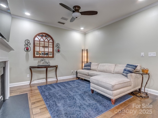 living room featuring crown molding, hardwood / wood-style floors, and ceiling fan