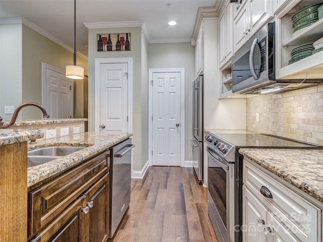 kitchen featuring pendant lighting, sink, white cabinetry, stainless steel appliances, and light stone countertops