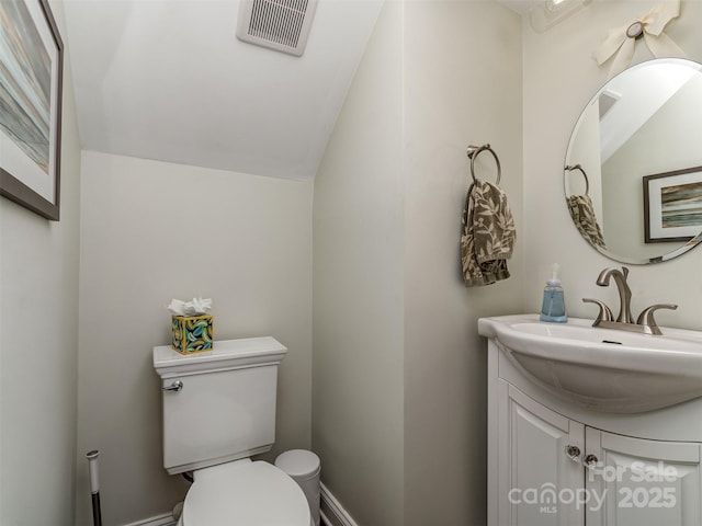 bathroom featuring vanity, lofted ceiling, and toilet