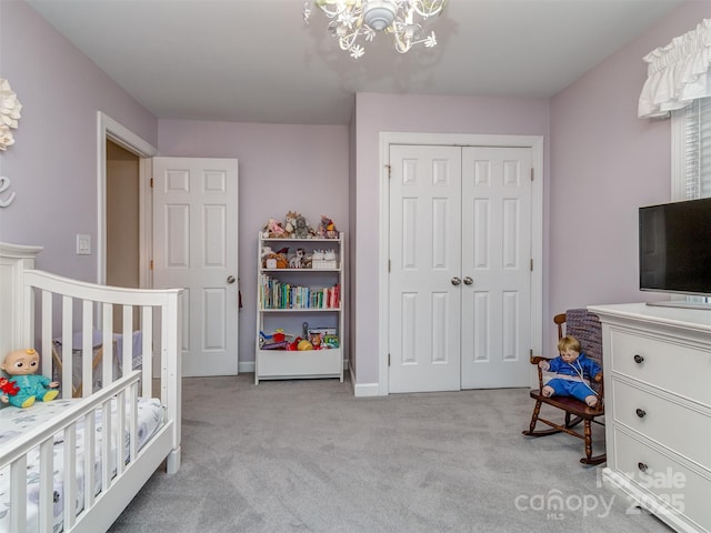 bedroom featuring light carpet, a chandelier, and a closet