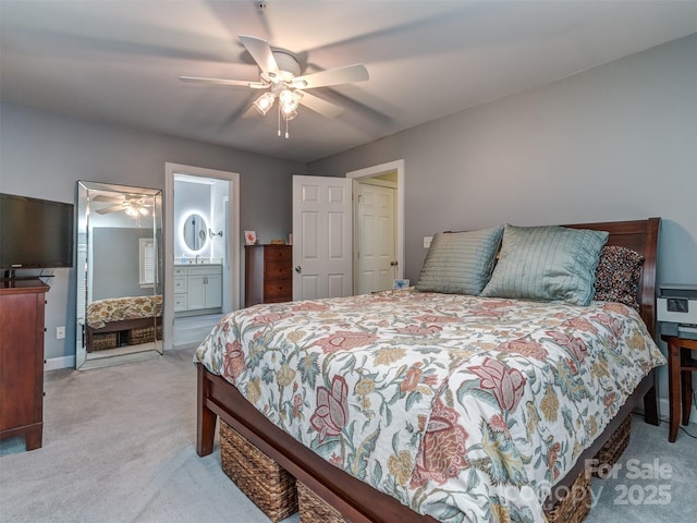 bedroom with connected bathroom, light colored carpet, and ceiling fan