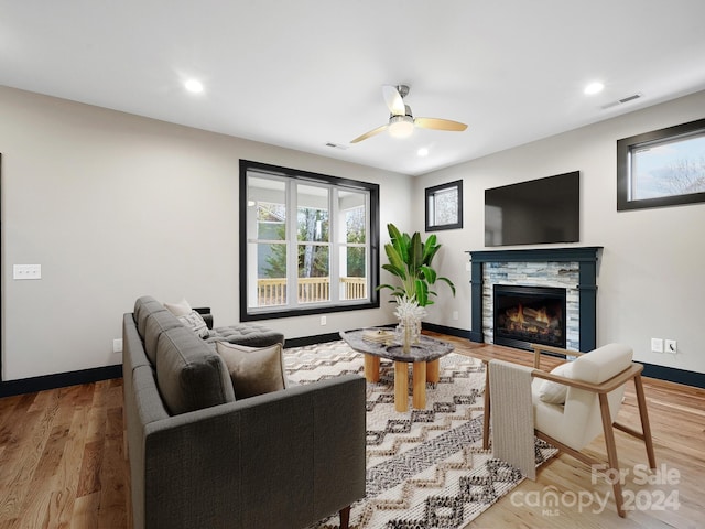 living room with a fireplace, hardwood / wood-style flooring, and ceiling fan