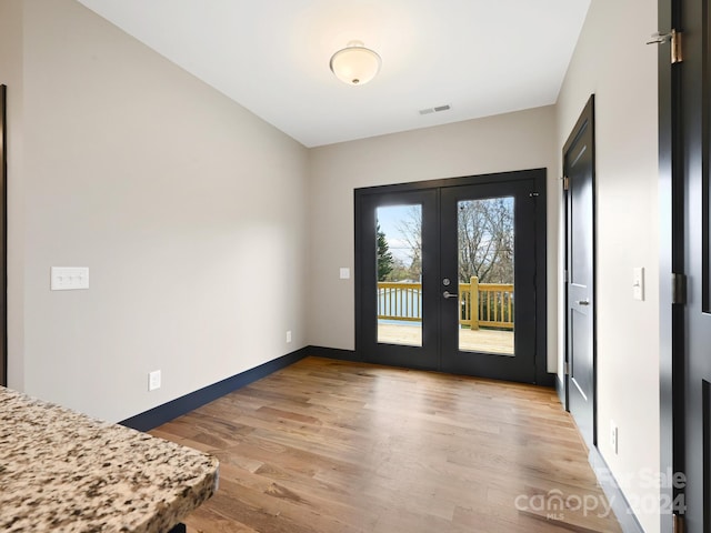 entryway featuring french doors and light wood-type flooring