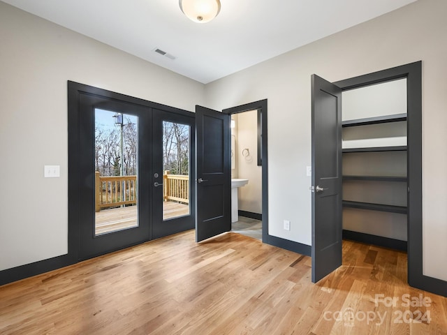 unfurnished bedroom with access to outside, light hardwood / wood-style flooring, and french doors