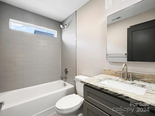 full bathroom with tile patterned floors, vanity, tiled shower / bath, and toilet