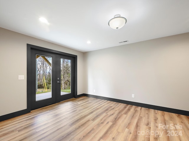 unfurnished room with light wood-type flooring and french doors