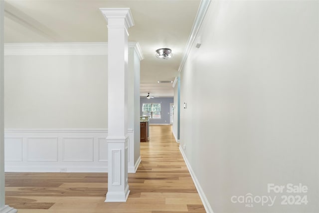 corridor featuring ornate columns, light hardwood / wood-style flooring, and ornamental molding