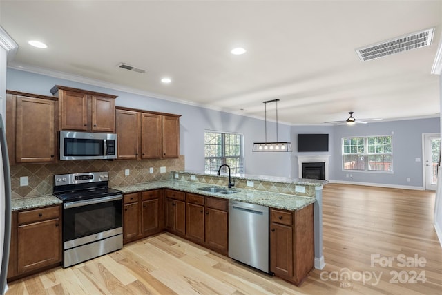 kitchen featuring a healthy amount of sunlight, sink, stainless steel appliances, and light hardwood / wood-style floors