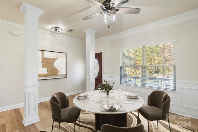 dining space featuring light hardwood / wood-style flooring, ceiling fan, crown molding, and ornate columns