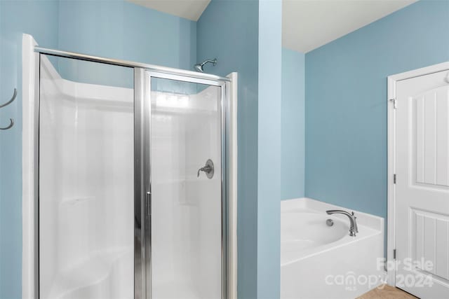 bathroom featuring separate shower and tub