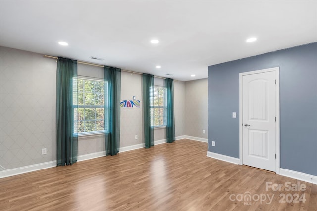 spare room featuring tile walls and hardwood / wood-style flooring