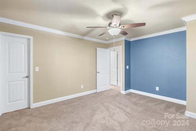 carpeted spare room with ceiling fan and crown molding