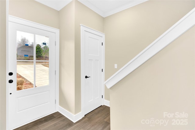 foyer with ornamental molding and dark hardwood / wood-style floors