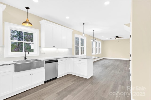 kitchen featuring sink, hanging light fixtures, stainless steel dishwasher, and kitchen peninsula