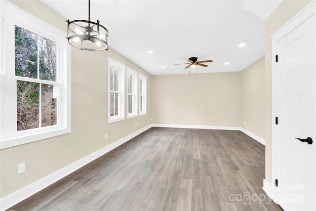 empty room featuring baseboards, wood finished floors, and recessed lighting