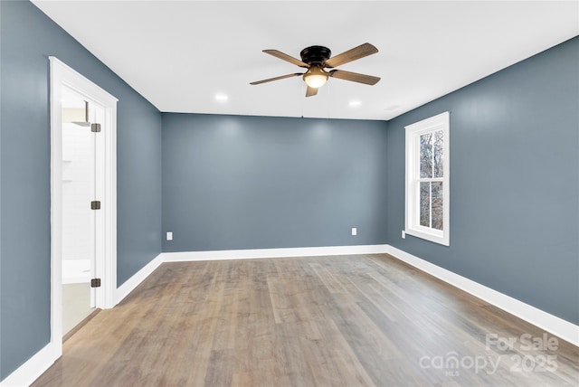 empty room featuring a ceiling fan, baseboards, and wood finished floors