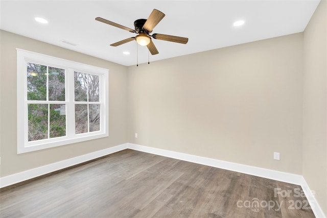 unfurnished room featuring visible vents, baseboards, wood finished floors, and recessed lighting