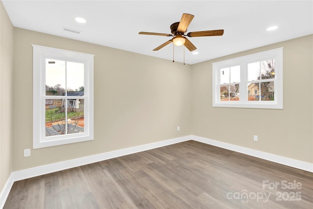 unfurnished room with baseboards, visible vents, dark wood-style floors, ceiling fan, and recessed lighting