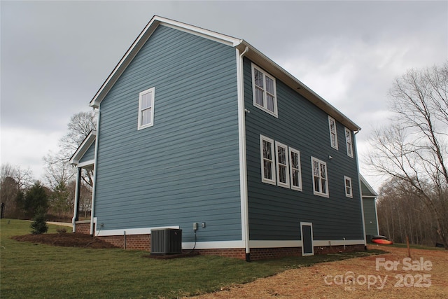 view of side of property featuring central AC and a yard