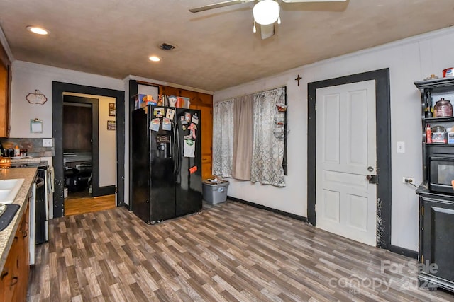 kitchen featuring dark hardwood / wood-style flooring, black fridge, and ceiling fan