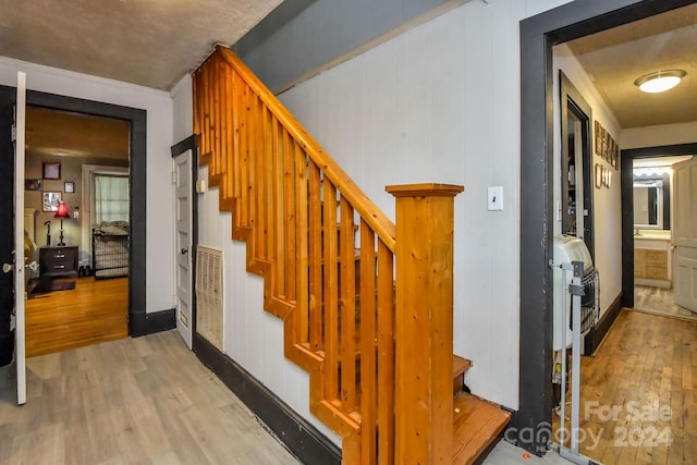 stairs featuring hardwood / wood-style floors and wood walls