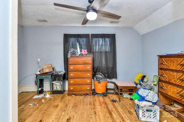 interior space featuring a textured ceiling, ceiling fan, hardwood / wood-style floors, and vaulted ceiling