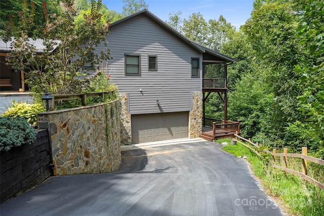 view of property exterior featuring a balcony, a deck, and a garage