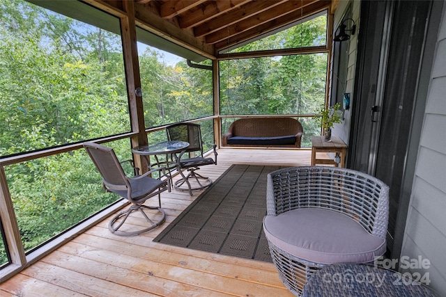 sunroom / solarium with vaulted ceiling with beams