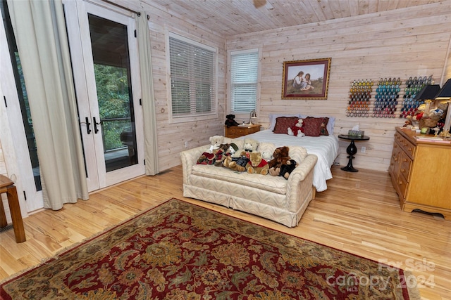 bedroom featuring access to outside, multiple windows, wood walls, and wood ceiling