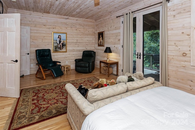 bedroom featuring access to exterior, light hardwood / wood-style floors, wooden ceiling, and wood walls