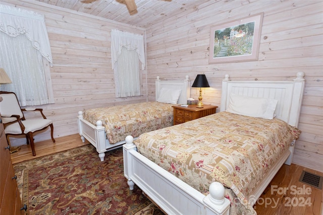 bedroom featuring ceiling fan, wooden walls, wood ceiling, and dark hardwood / wood-style floors