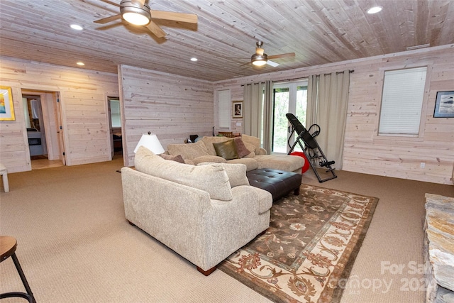 living room featuring carpet, wooden walls, ceiling fan, and wooden ceiling