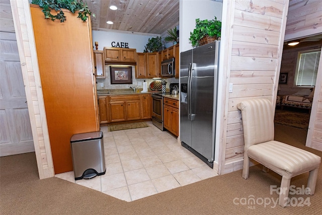 kitchen featuring light colored carpet, sink, wood ceiling, and stainless steel appliances