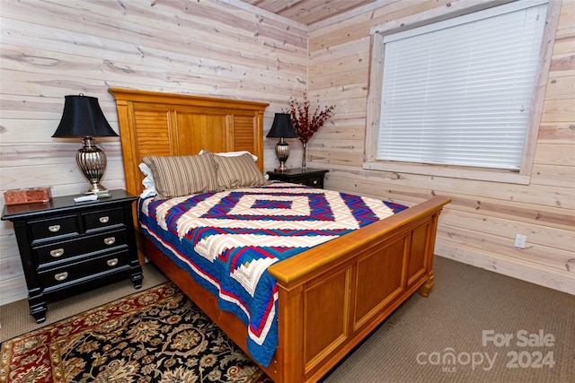 carpeted bedroom featuring wooden walls