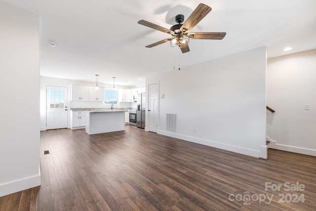 unfurnished living room with dark hardwood / wood-style floors and ceiling fan